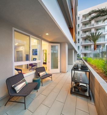 a patio with chairs and a table on a balcony